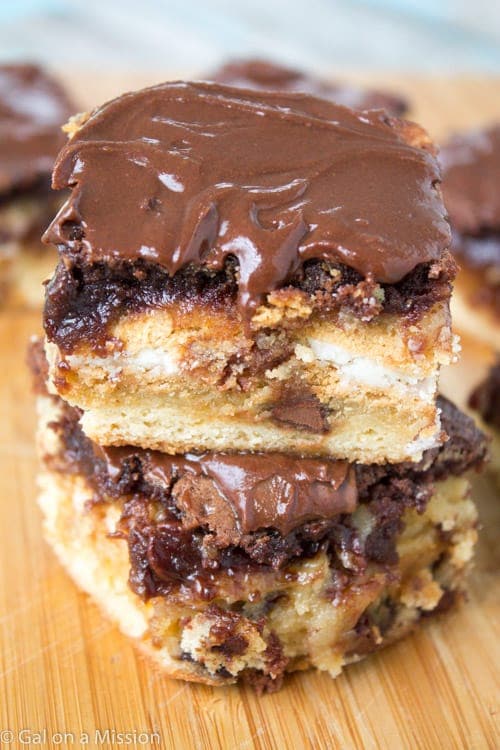 chocolate brownie bars stacked on a cutting board.