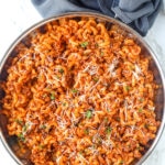 tomato meat sauce in elbow noodles topped with parmesan cheese and parsley