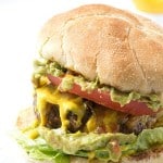 Juicy Cheddar Cheese Burger with Guacamole - The Ultimate basic cheeseburger loaded with shredded cheese, onions; and then topped with cheddar cheese, tomato slice, guacamole!