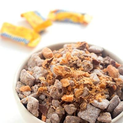 Butterfinger Muddy Buddies - The perfect treat to make any day of the year! So addicting you will not be able to stop.