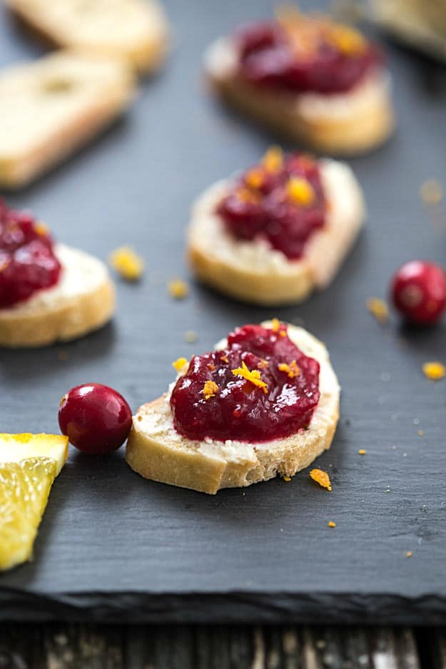 Cranberry Orange Crostini - A decadent crostini made with an out-of-this-world cheese spread, then topped with fresh cranberry sauce and orange zest! Perfect appetizer for the holidays.