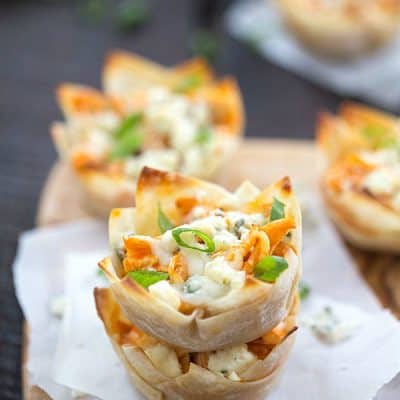 Cheesy Buffalo Chicken Cups Recipe - Tender chicken seasoned with the best hot sauce, then topped with cheesy mozzarella cheese, then finished with crumbled blue cheese! One of our favorite appetizers for a party! If you like buffalo wings, buffalo chicken dip, or pasta you are going to love this!