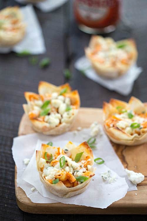 Cheesy Buffalo Chicken Cups Recipe - Tender chicken seasoned with the best hot sauce, then topped with cheesy mozzarella cheese, then finished with crumbled blue cheese! One of our favorite appetizers for a party! If you like buffalo wings, buffalo chicken dip, or pasta you are going to love this!