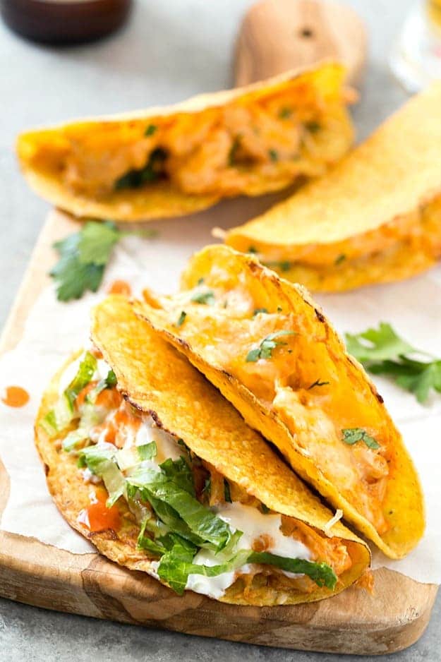 Oven Baked Buffalo Chicken Tacos - These super easy oven baked tacos are loaded with creamy buffalo chicken mixture and then topped with extra shredded cheese! Perfect recipe for taco Tuesday or any day of the week! So much flavor without all of the mess.