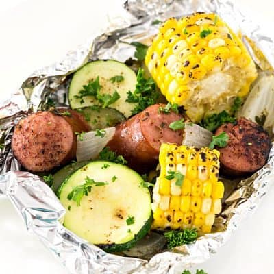 Kielbasa Sausage & Grilled Vegetables in Foil - These foil packets are so quick to assemble! Perfect for camping or a quick dinner. Packed with sausage, zucchini, and corn with the most amazing seasoning! A family favorite any night of the week.