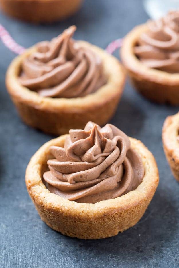 Peanut Butter Nutella Fudge Cookie Cups are so soft and fluffy and filled with an outrageous Nutella fudge frosting! Can be made in a regular muffin tin or even in a mini!