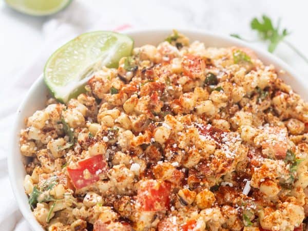 Mexican Street Corn Salad is so creamy and flavored with the perfect amount of spices, fresh lime juice, and zest, with a touch of crunch and a kick of jalapeno! Perfect all year long! 