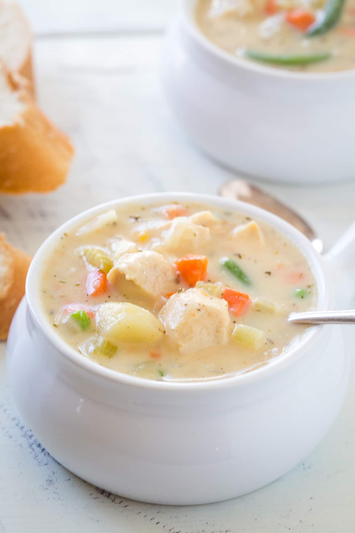 Looking at chicken pot pie soup is a soup bowl with a spoon