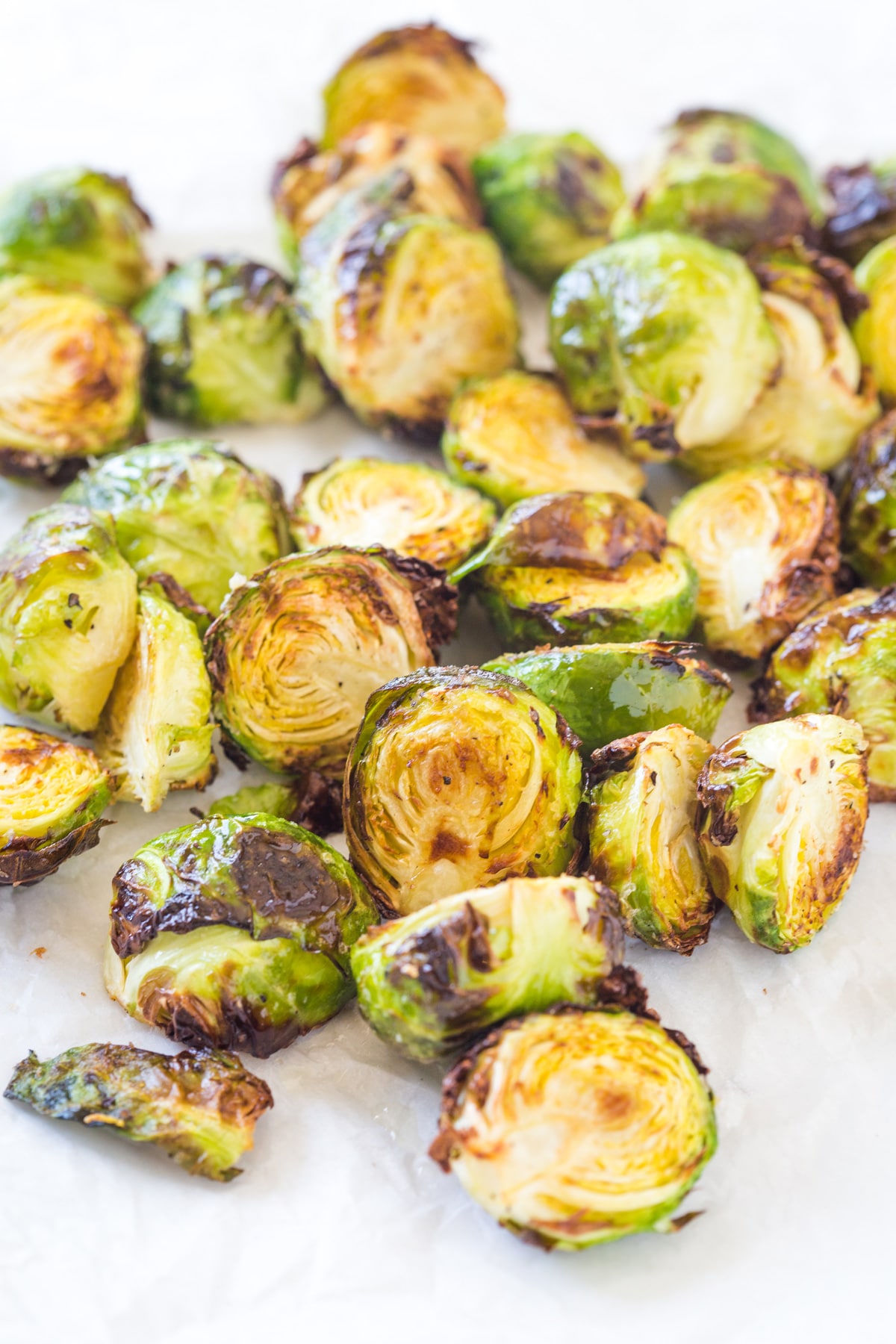 looking at air fried brussels sprouts on a white background