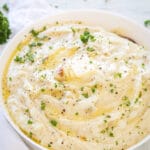 roasted garlic mashed potatoes in a white bowl on a white background