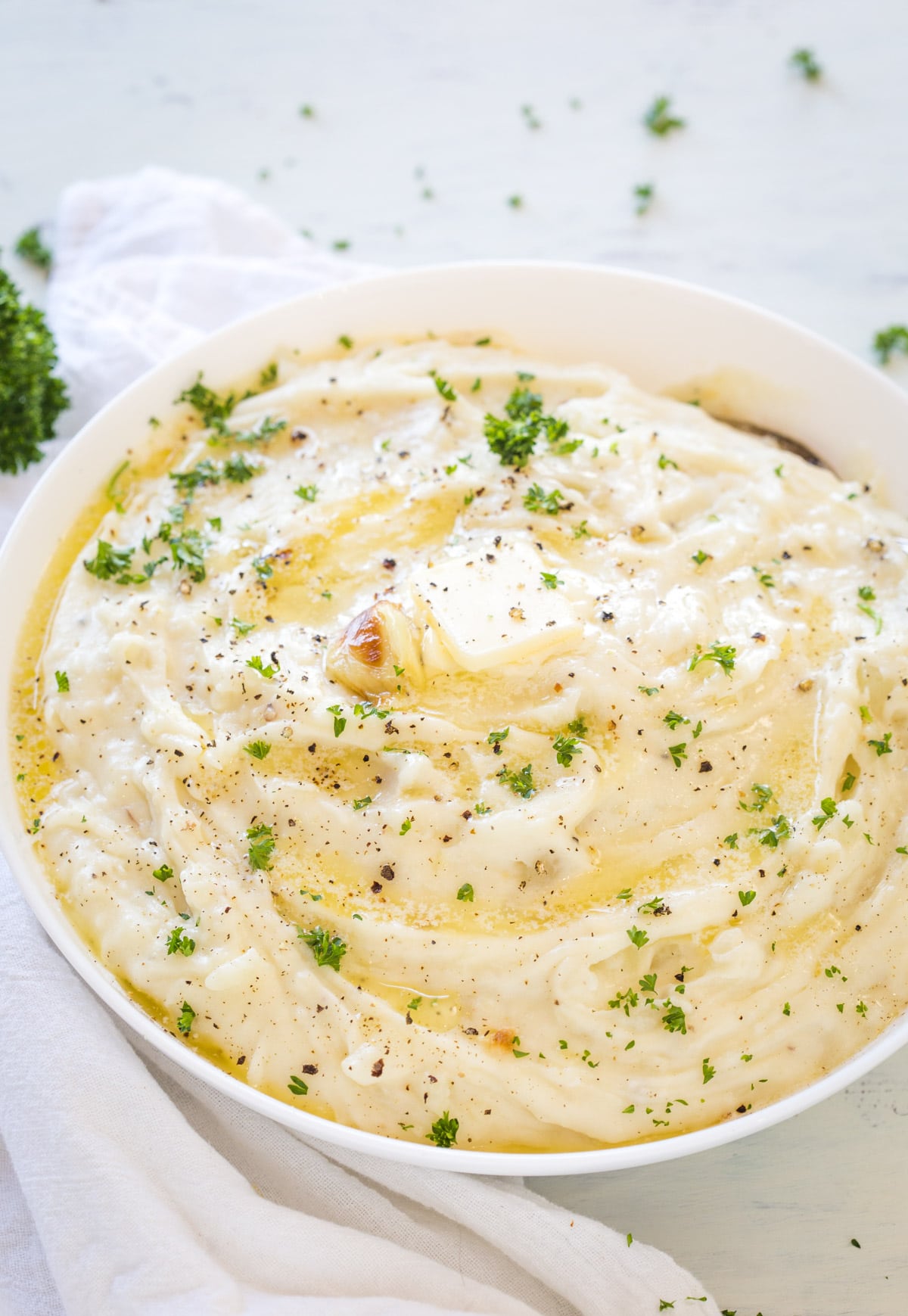 roasted garlic mashed potatoes in a white bowl on a white background