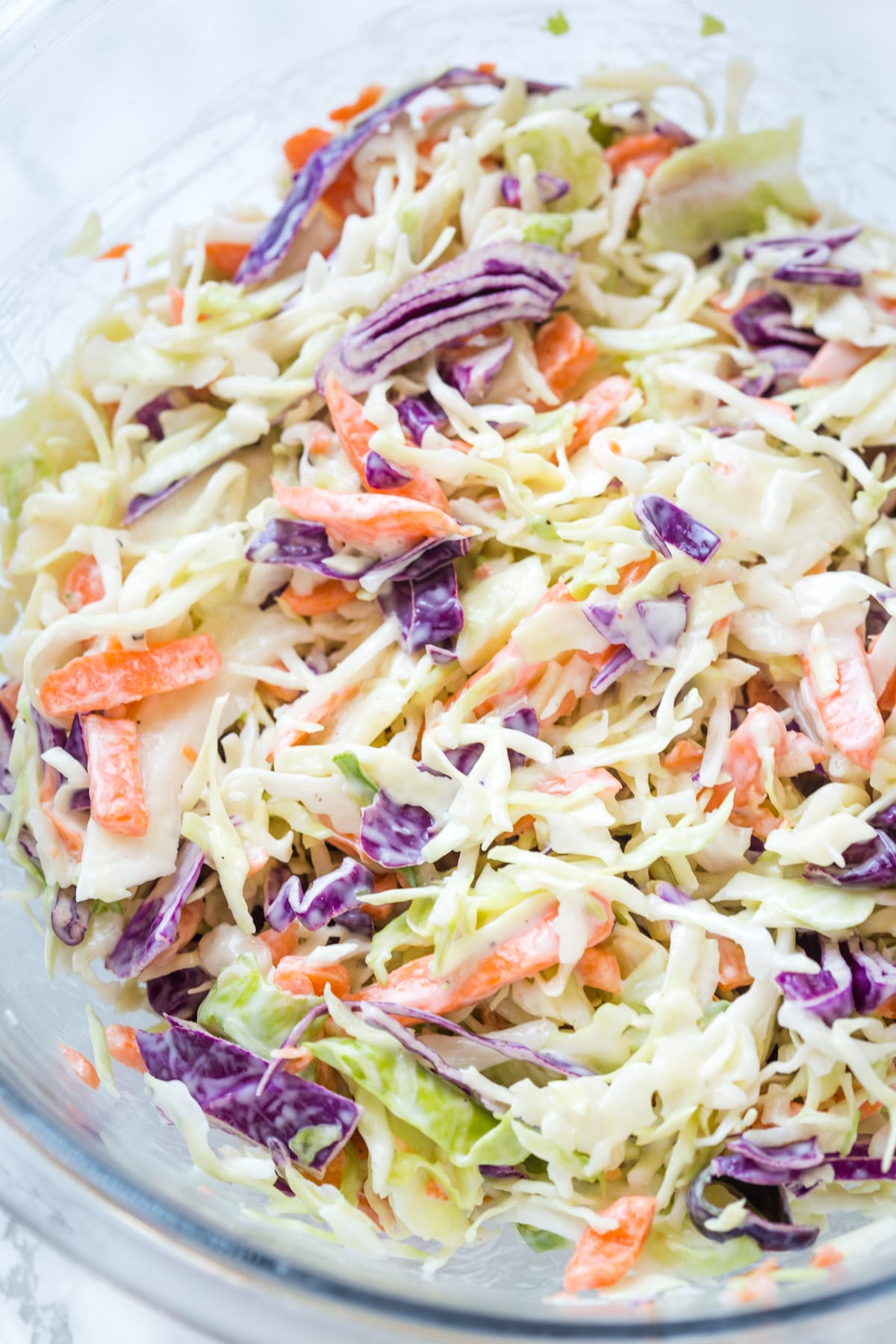 Closeup of creamy coleslaw in a glass bowl