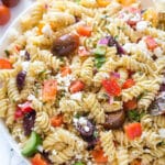 Close up of Greek pasta salad in a bowl bowl on a marble surface