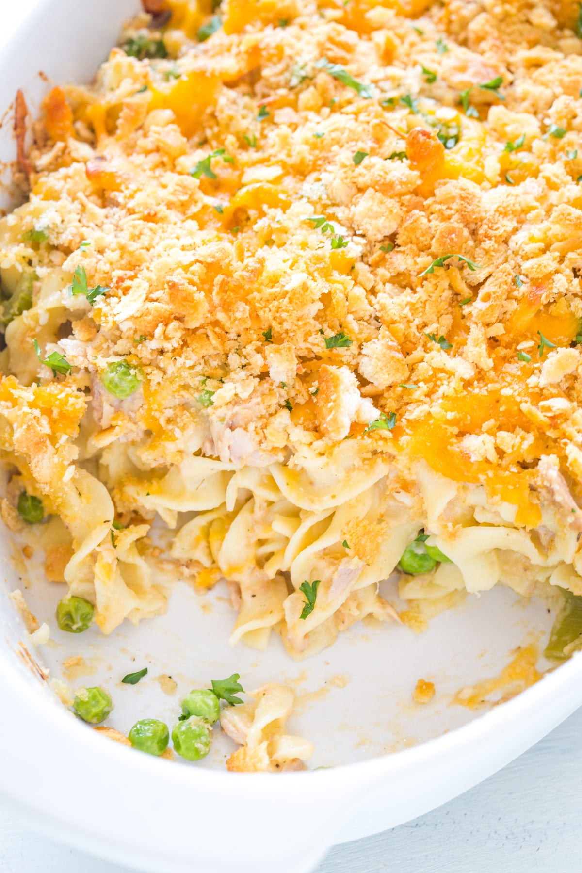 Closeup of baked tuna noodle casserole in a white casserole dish